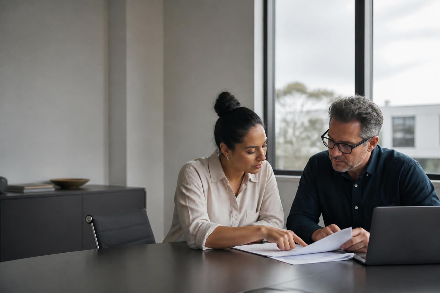 Finance and operations managers reviewing working papers together